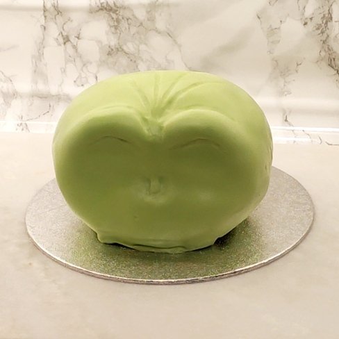 Carving the face shape into the fondant